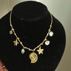 Gold Charm Seashell Necklace with Mixed Charms